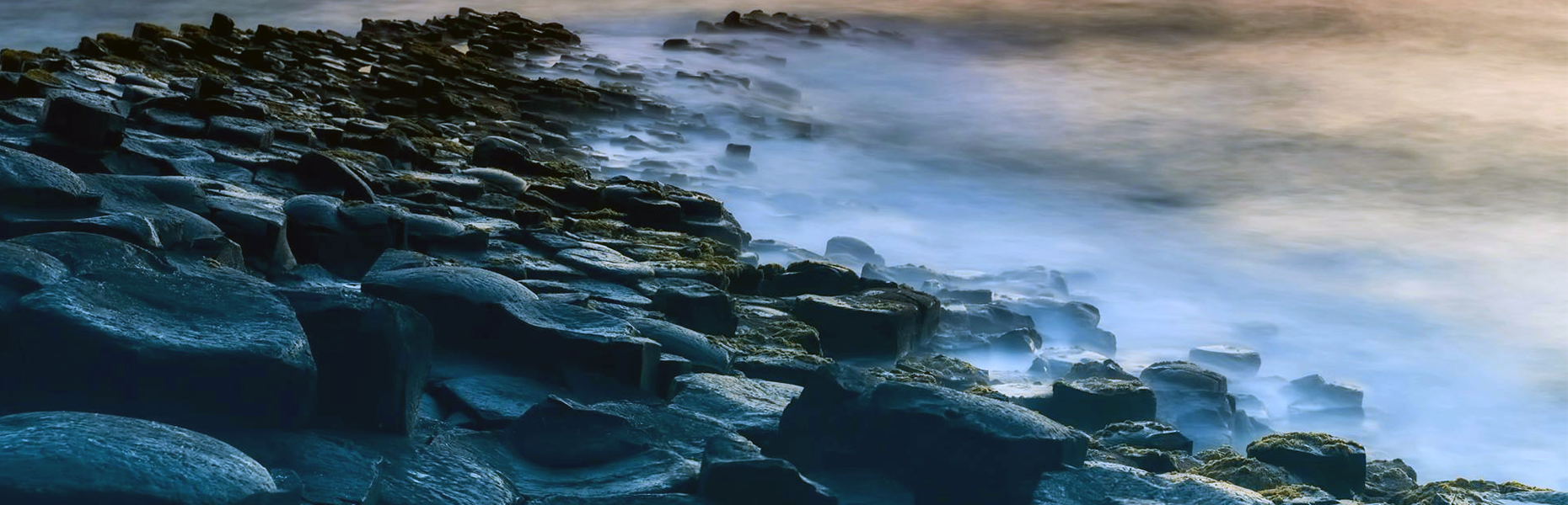 Waves breaking over dark rocks along the Irish coast