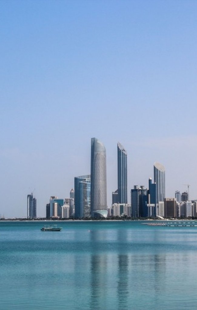 The Abu Dhabi skyline across calm blue water