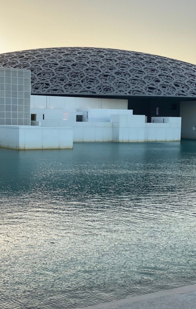 The latticed dome of the Louvre Abu Dhabi above still water