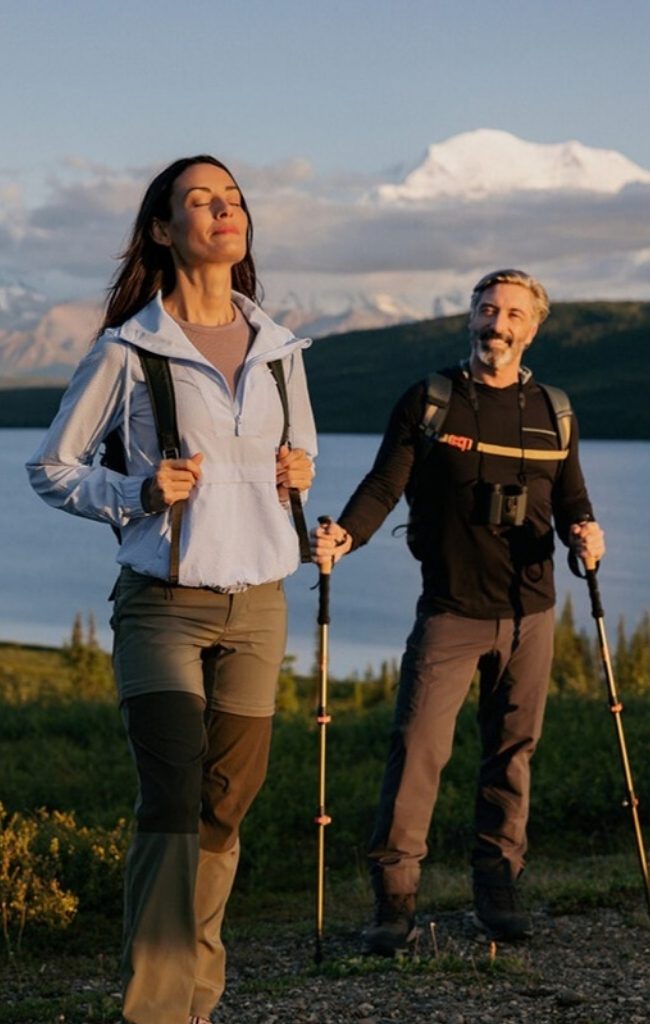 Two hikers at sunset with Denali in the distance