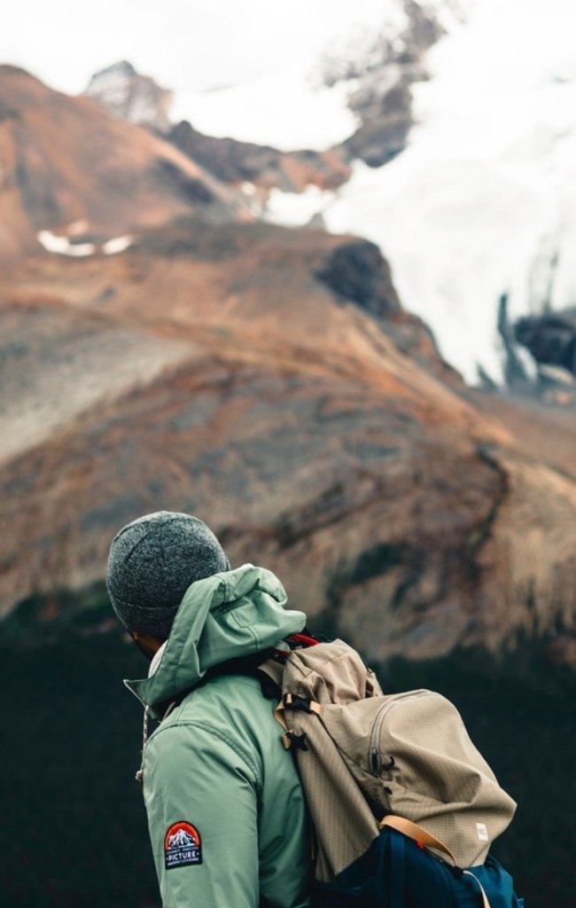 A hiker looking toward rugged peaks in the Canadian Rockies