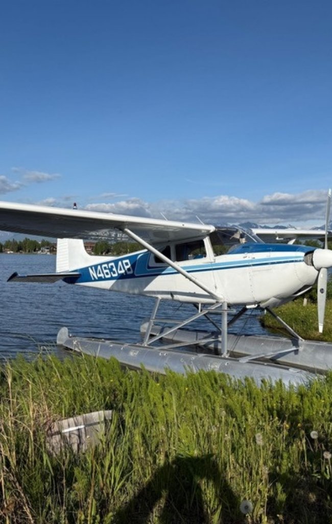 A floatplane moored on a lake below mountains