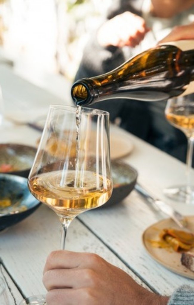 White wine being poured at a table outdoors