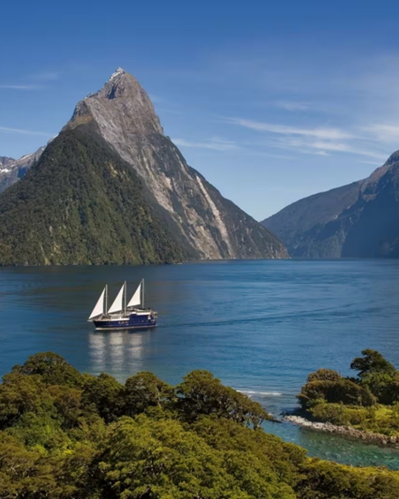 A sailing ship below Mitre Peak in Milford Sound, New Zealand
