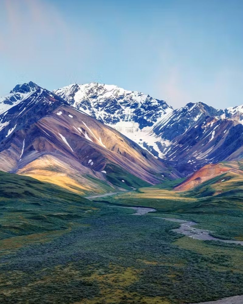 Snow-capped mountains above a wide river valley in Alaska