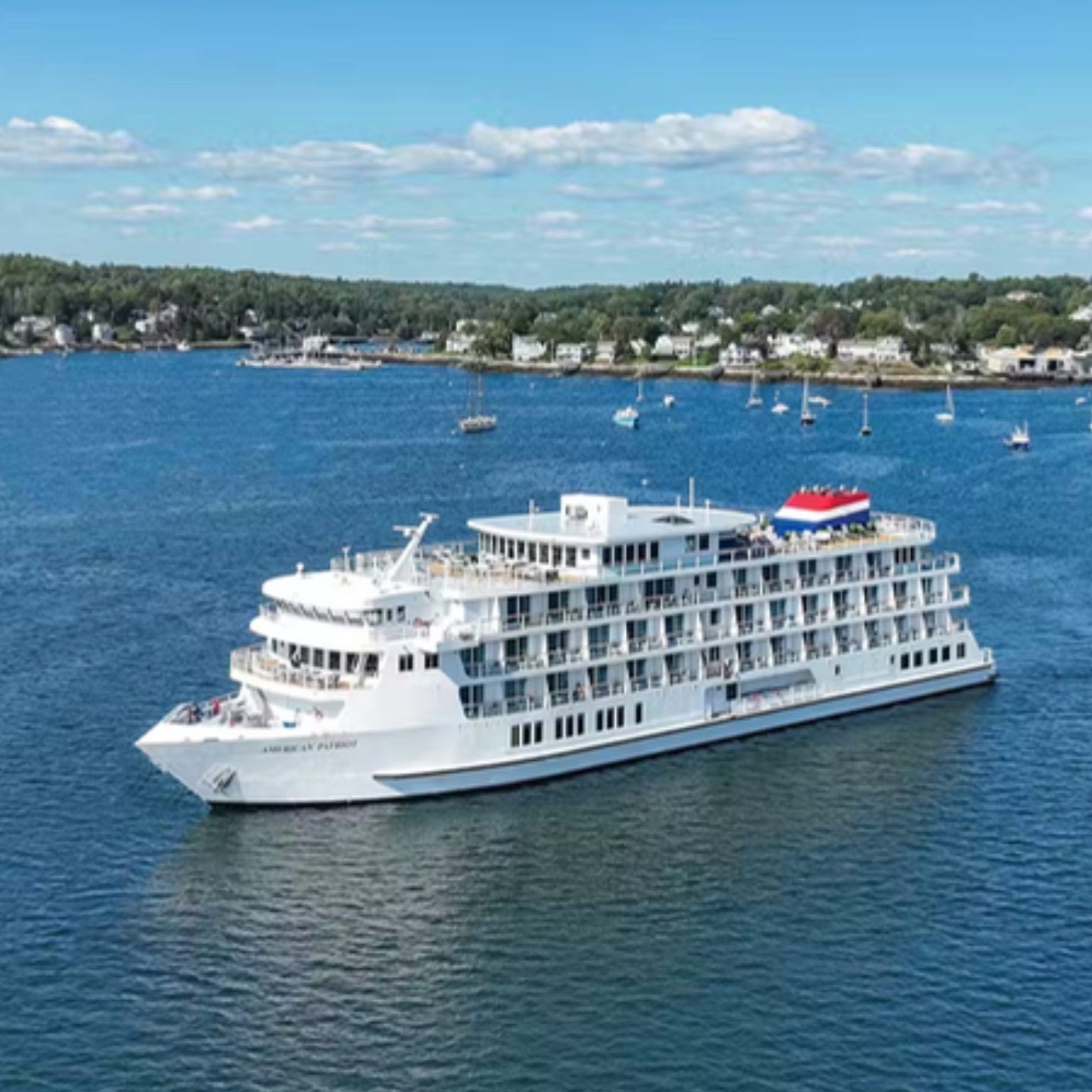 An American Cruise Lines ship cruising a harbor on a sunny day
