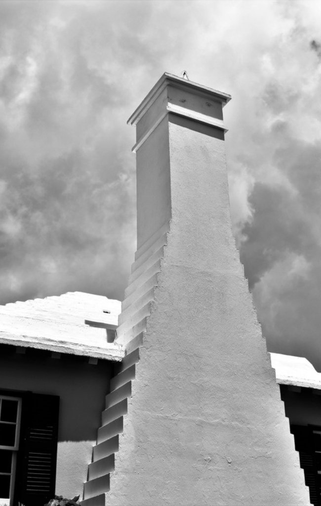 A whitewashed stepped chimney and roof in traditional Bermudian style