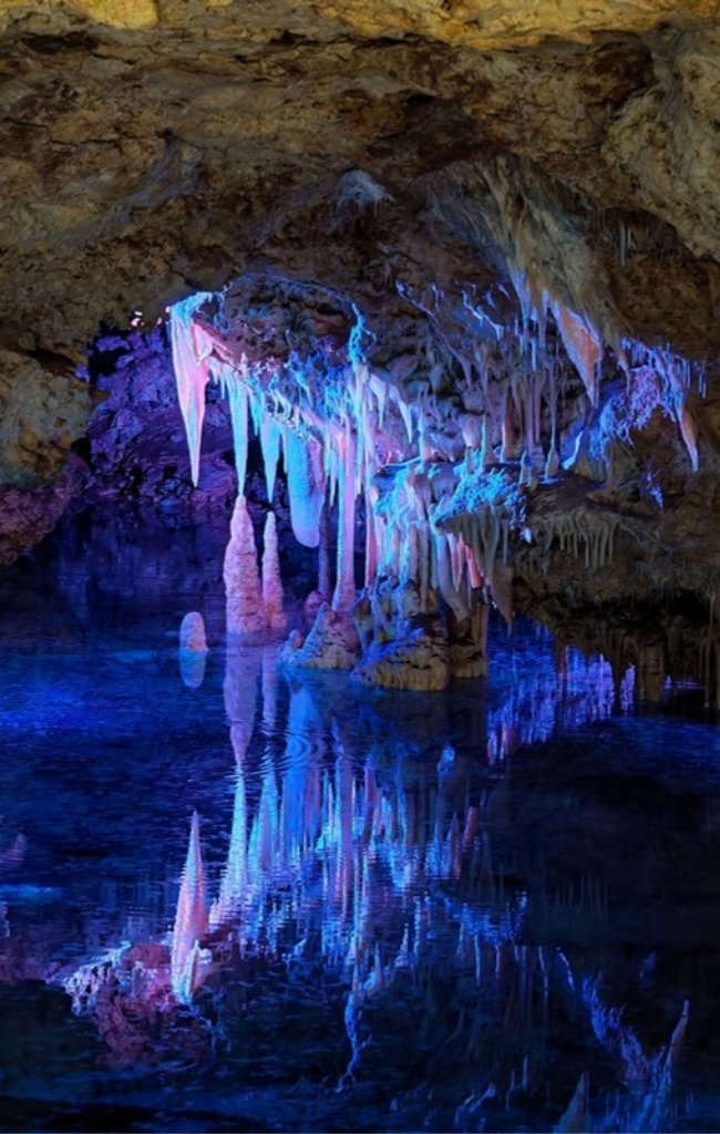 Stalactites reflected in a clear underground pool