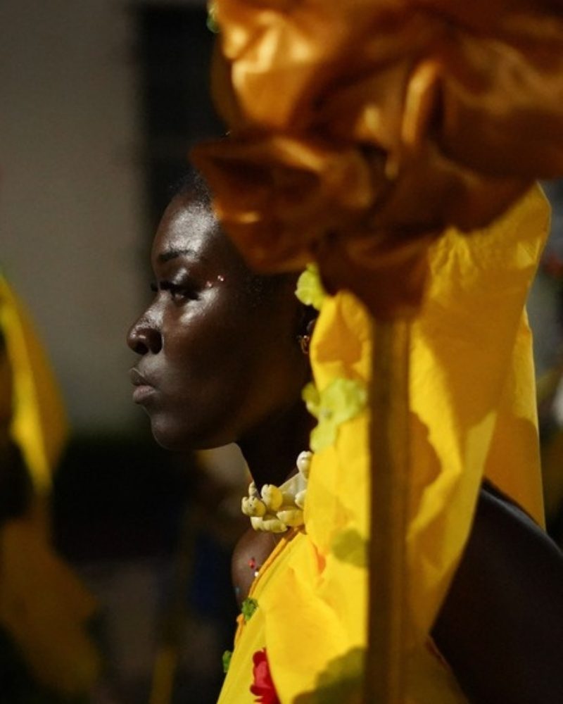 Performer in a bright yellow festival costume