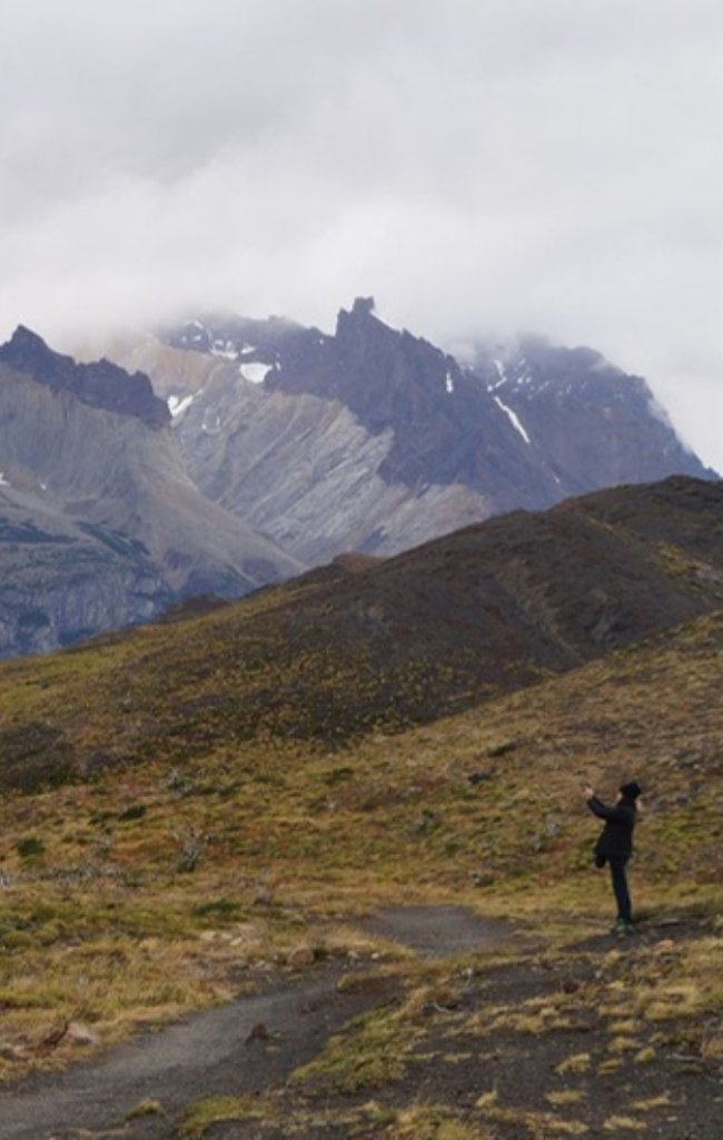 A hiker on a trail below the towers of Torres del Paine