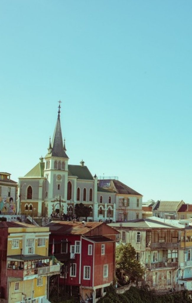 Colorful hillside houses and a church spire in Valparaíso