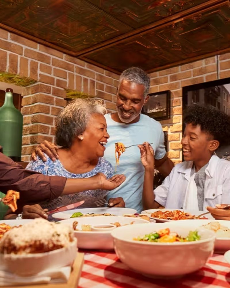 Three generations of a family sharing a pasta dinner