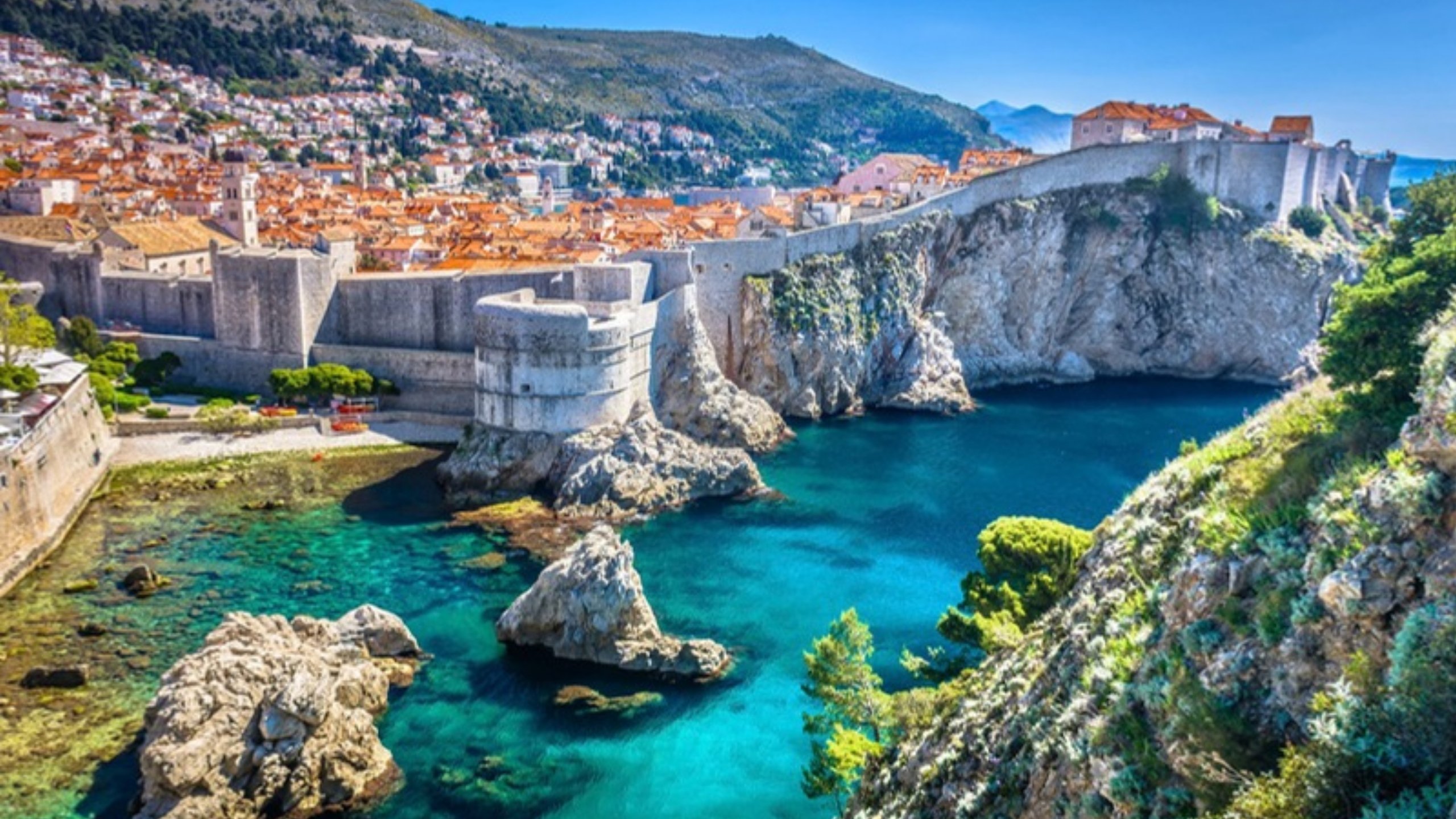 The walls of Dubrovnik above clear turquoise water