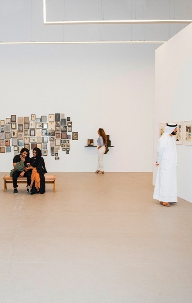 Visitors viewing artworks in a bright contemporary gallery