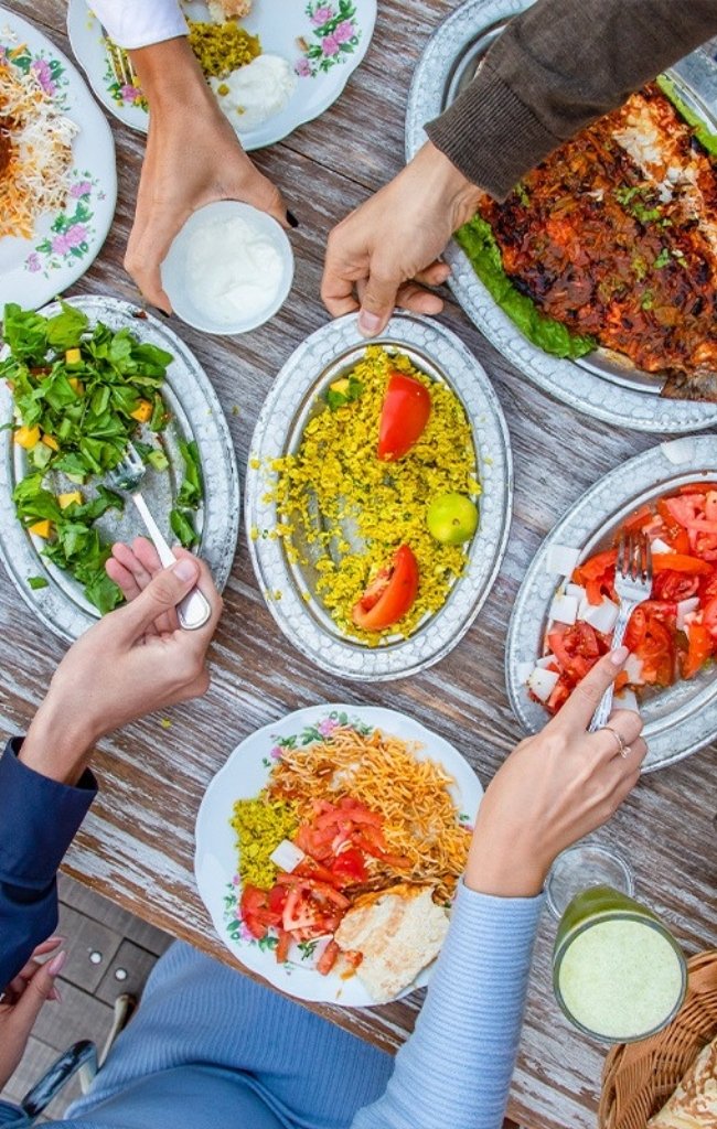 Friends sharing plates of Middle Eastern dishes
