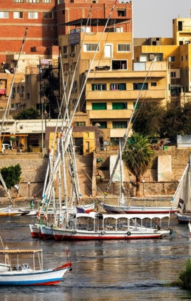 Feluccas sailing on the Nile along the Aswan riverfront