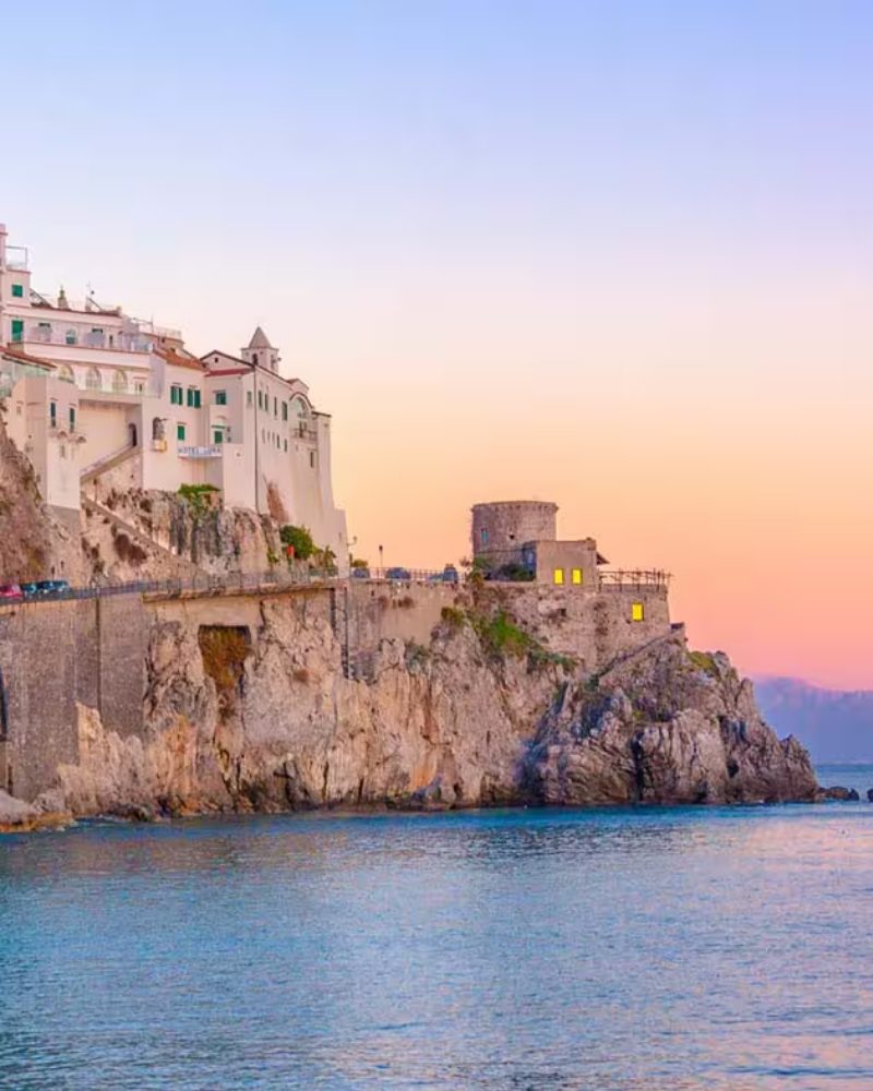 A cliffside town on the Mediterranean coast at sunset