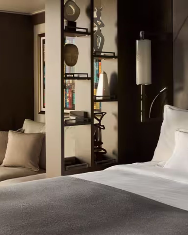 A suite with a bed, sofa and display shelves