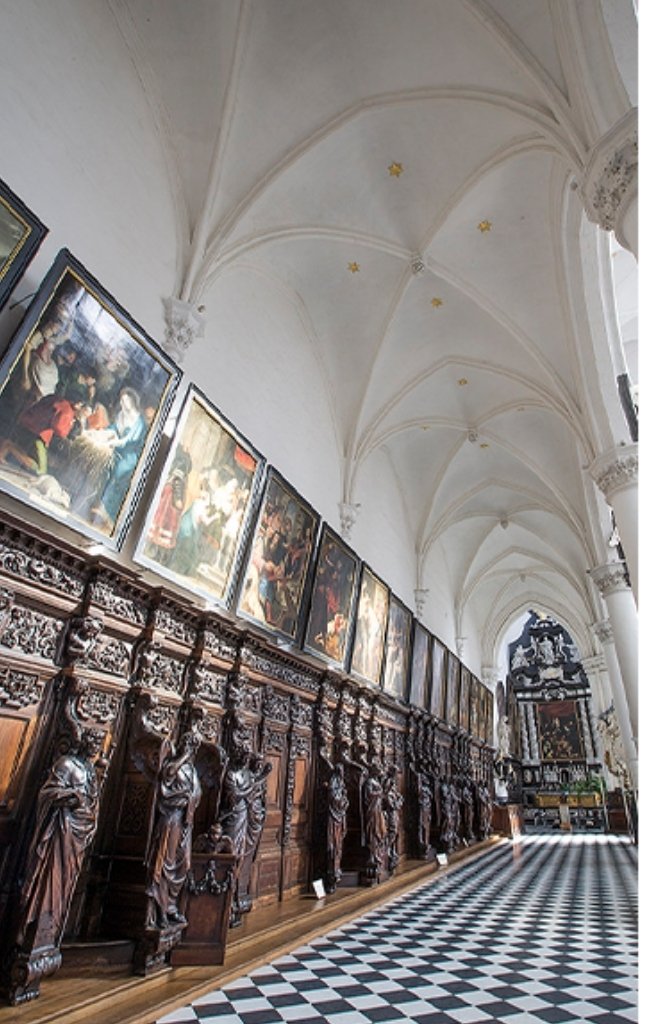 Paintings lining the nave of a Gothic church in Antwerp