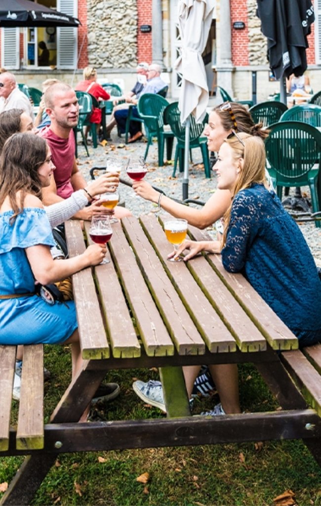 Friends sharing Belgian beers at an outdoor table