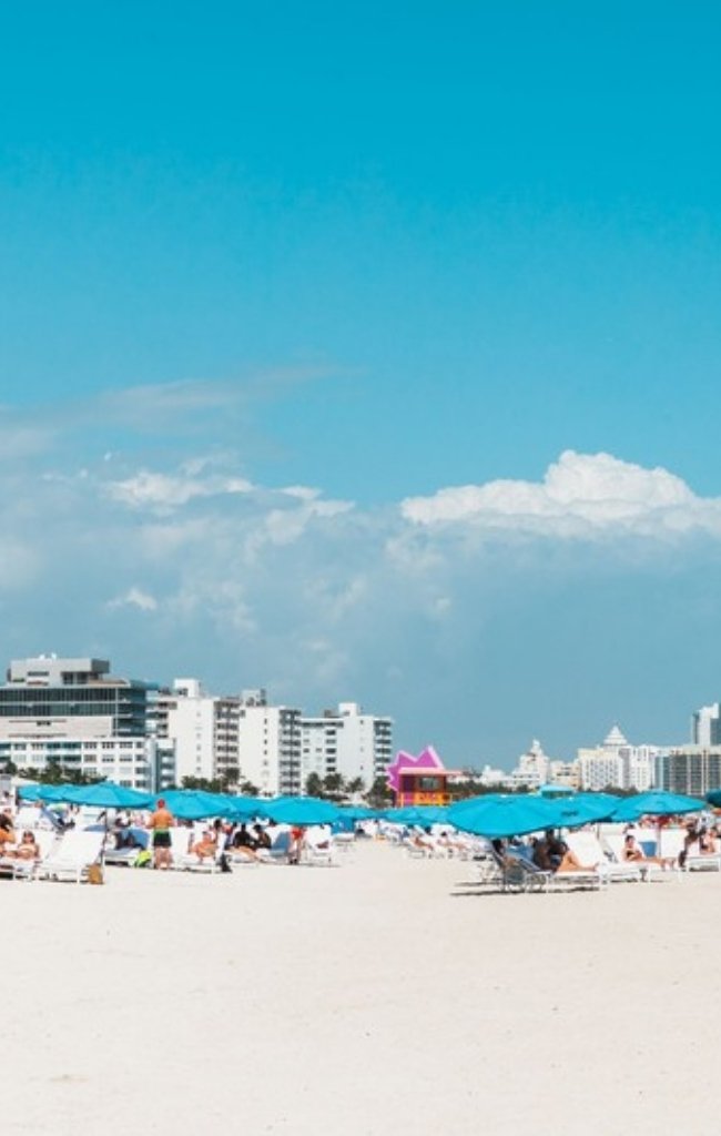 Blue umbrellas on the white sand of Miami Beach