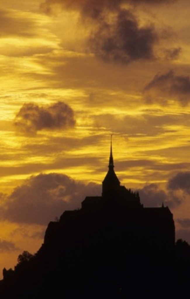 Mont-Saint-Michel silhouetted at sunset in Normandy