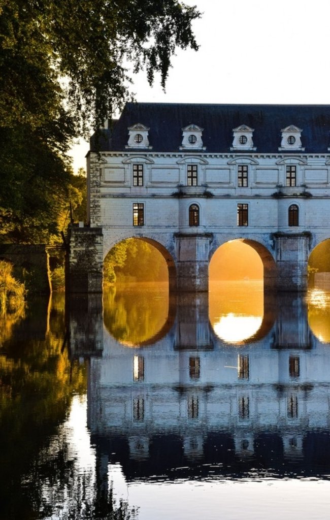The Chateau de Chenonceau reflected in the river at sunrise