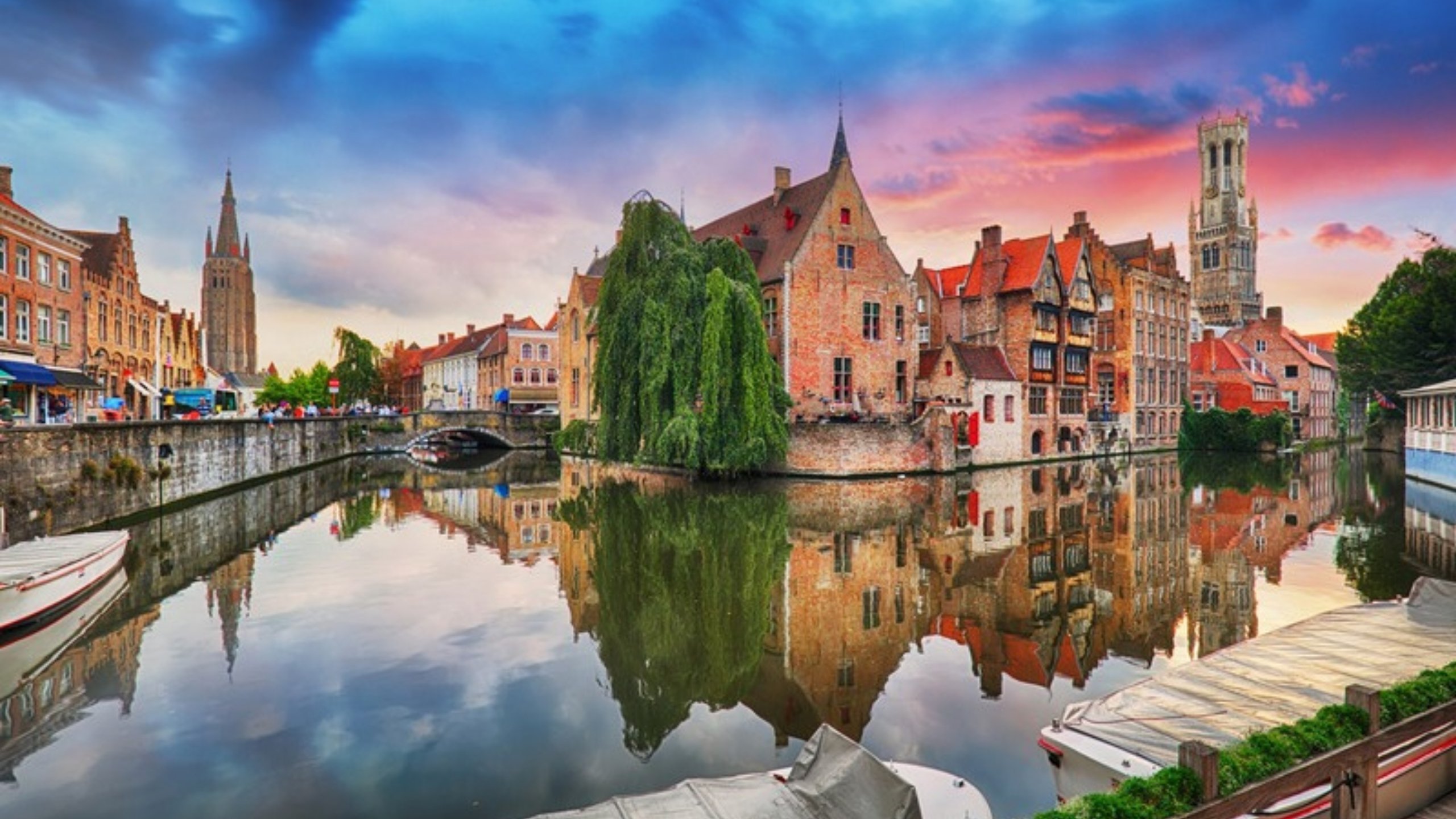 Medieval houses reflected in a Bruges canal at sunset