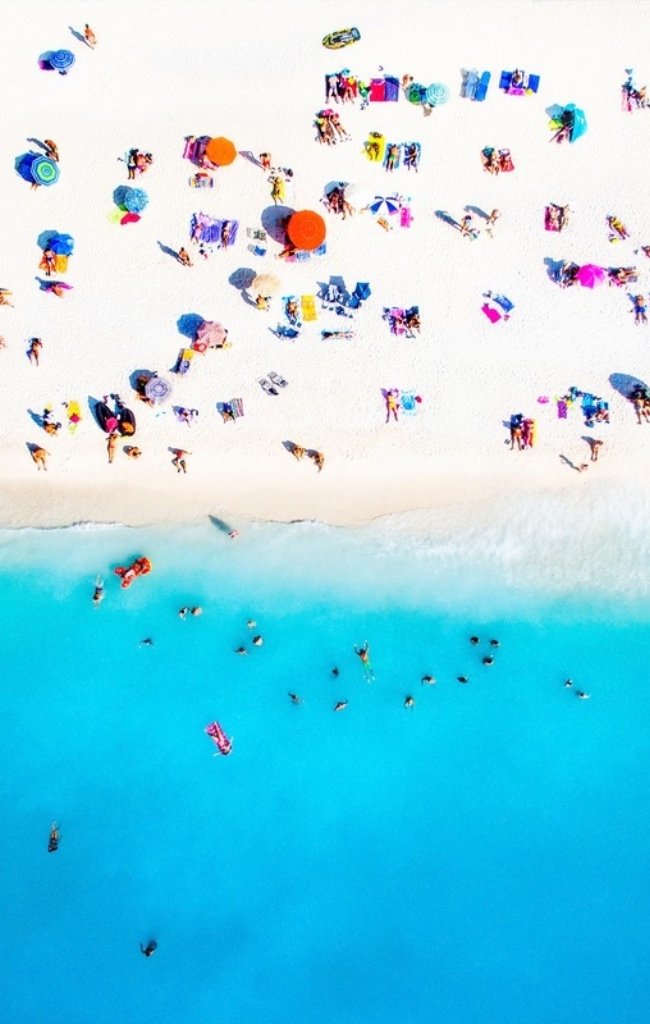 Aerial view of swimmers and umbrellas on a Greek beach