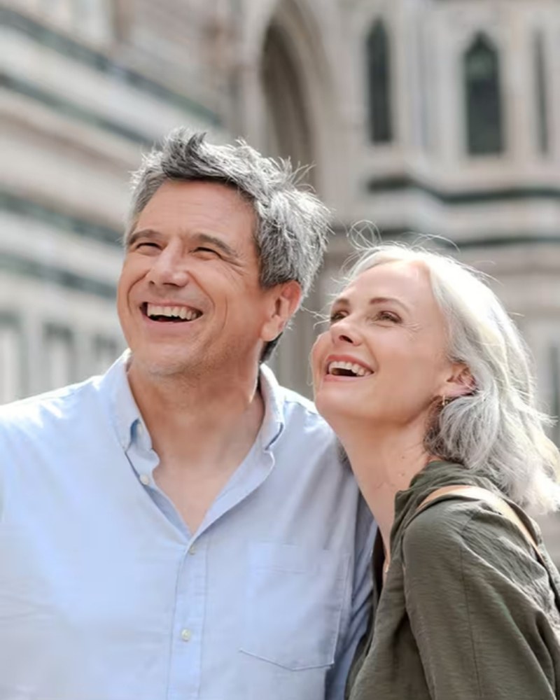 A couple smiling in front of Florence Cathedral