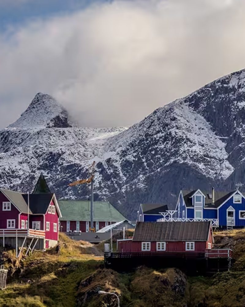 Colorful wooden houses below snow-capped mountains in the Arctic