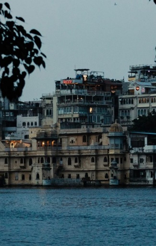 The City Palace of Udaipur seen from Lake Pichola at dusk
