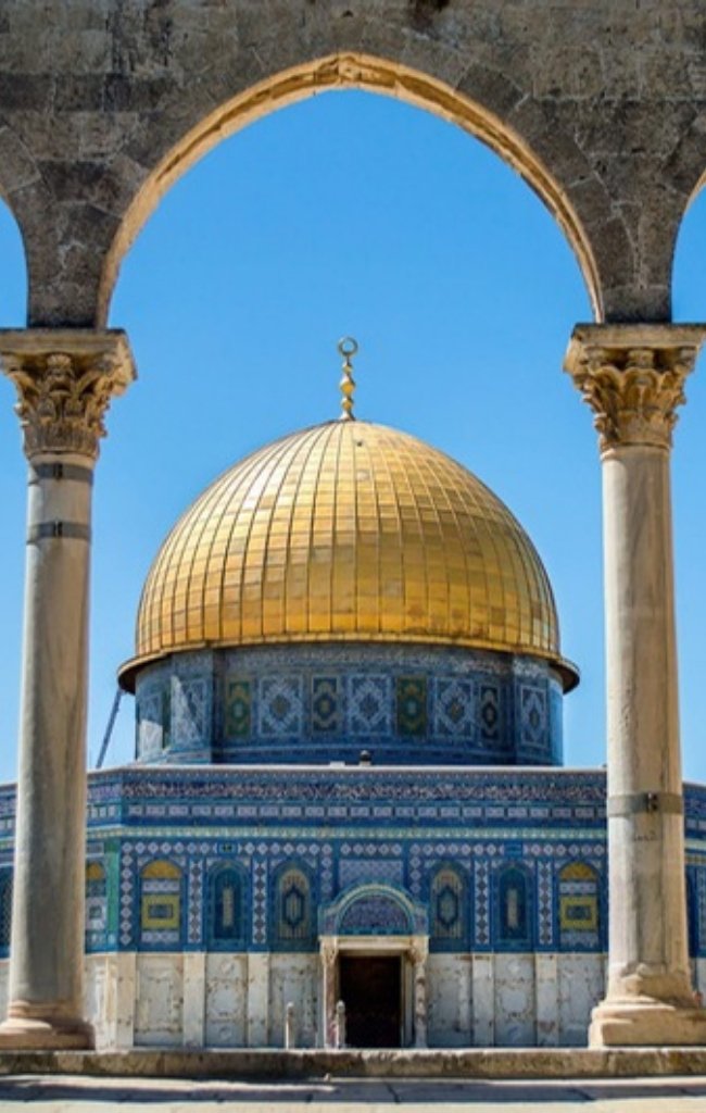 The golden Dome of the Rock framed by stone arches