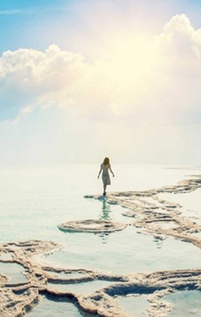 A woman walking along salt formations at the Dead Sea