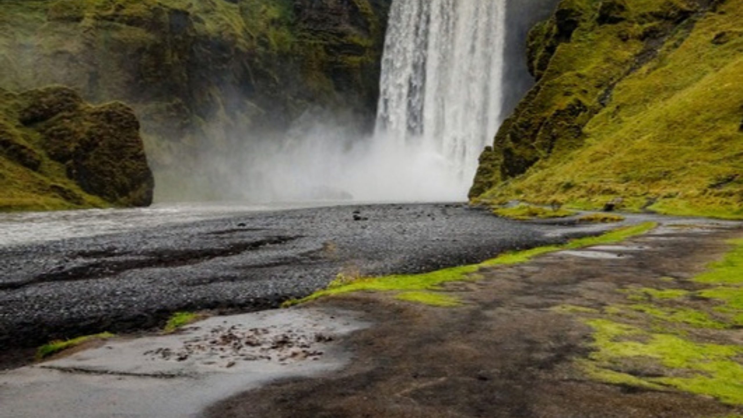Skogafoss waterfall surrounded by green hills in Iceland
