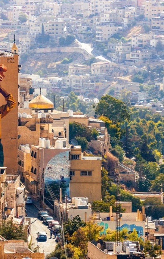 Hillside neighborhoods and a mural in central Amman