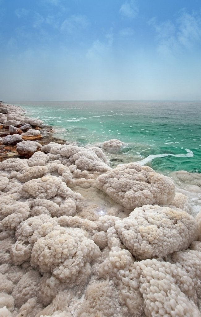 White salt formations along the turquoise shore of the Dead Sea