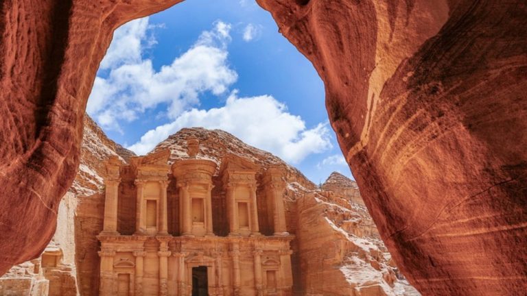 The Monastery at Petra framed by a sandstone cave opening