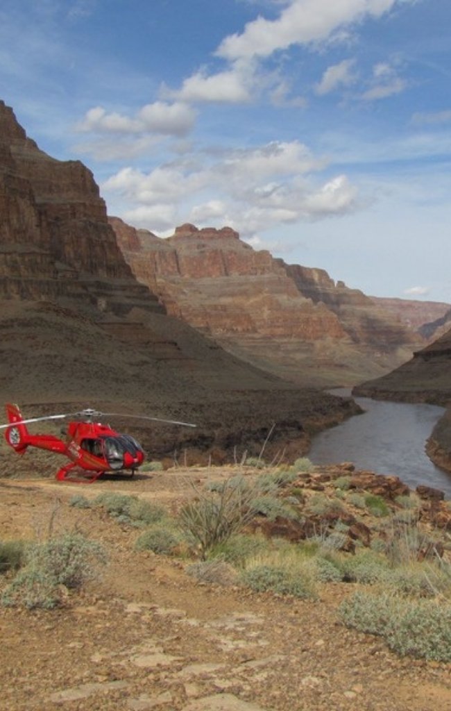 A helicopter landed beside the Colorado River in the Grand Canyon