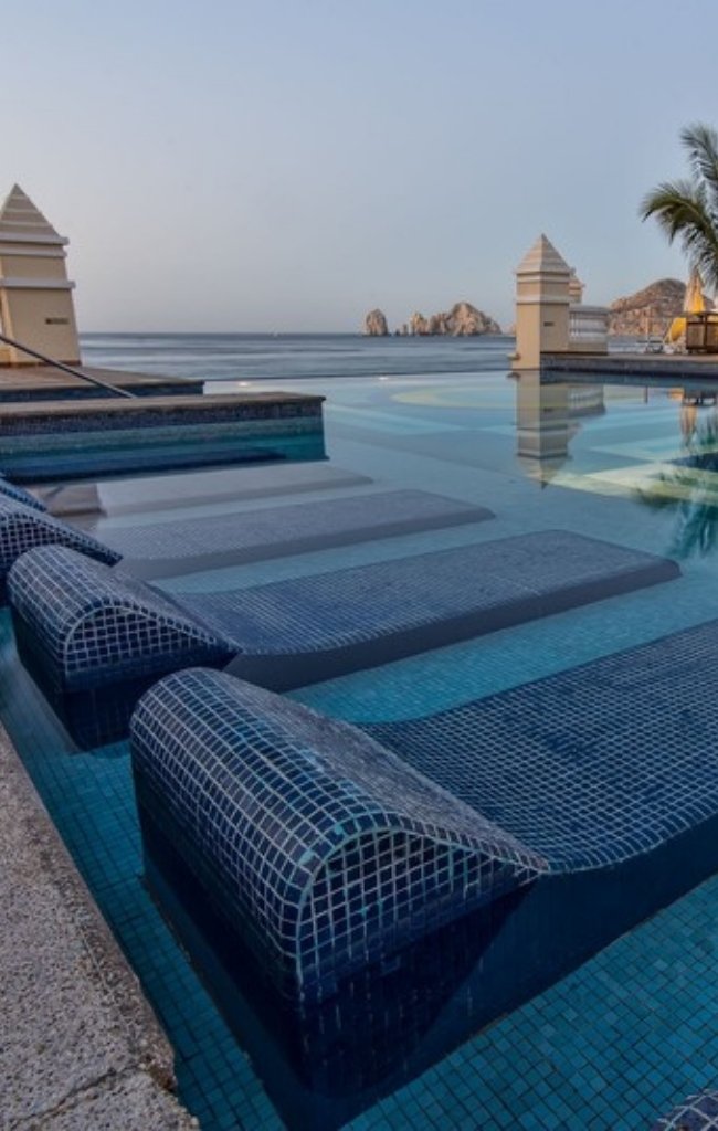 An infinity pool with sun loungers overlooking the sea at a resort on the Corridor