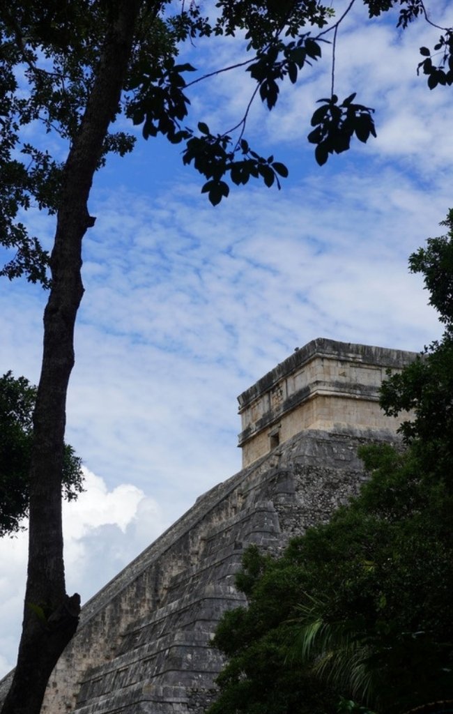 The stepped pyramid of El Castillo at Chichén Itzá framed by trees