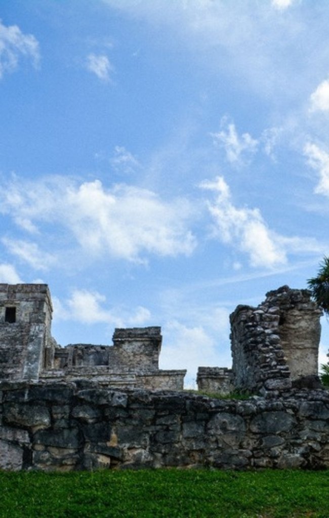 Stone Mayan ruins among palm trees in Tulum