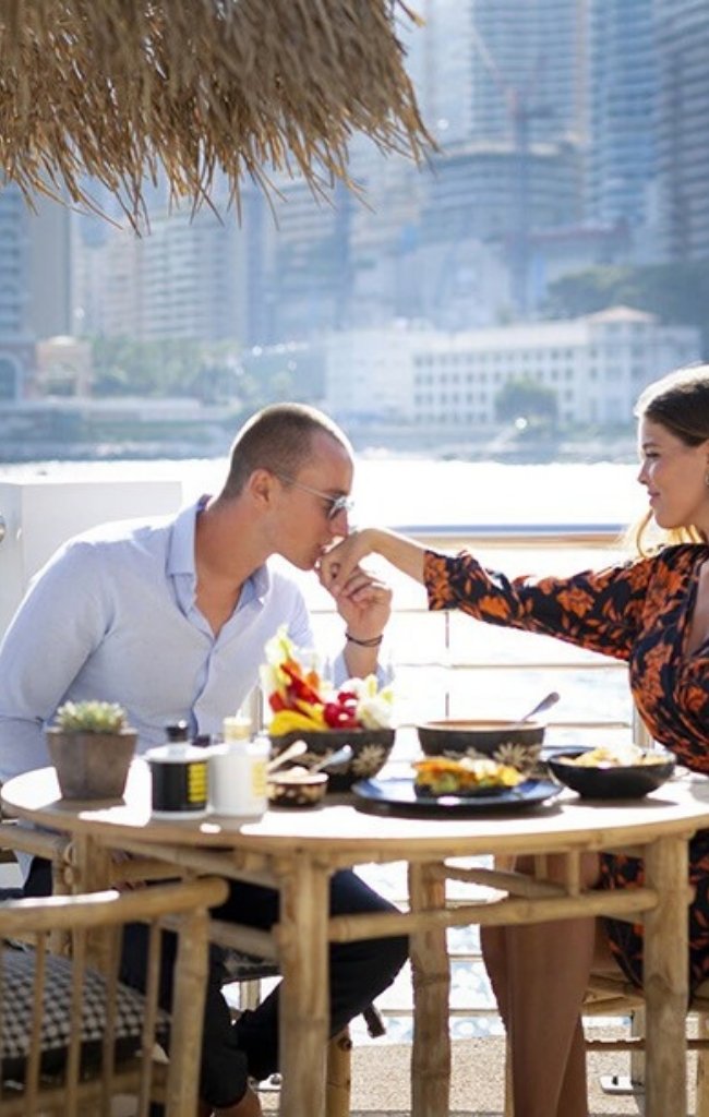 A couple sharing lunch on a terrace above the harbor