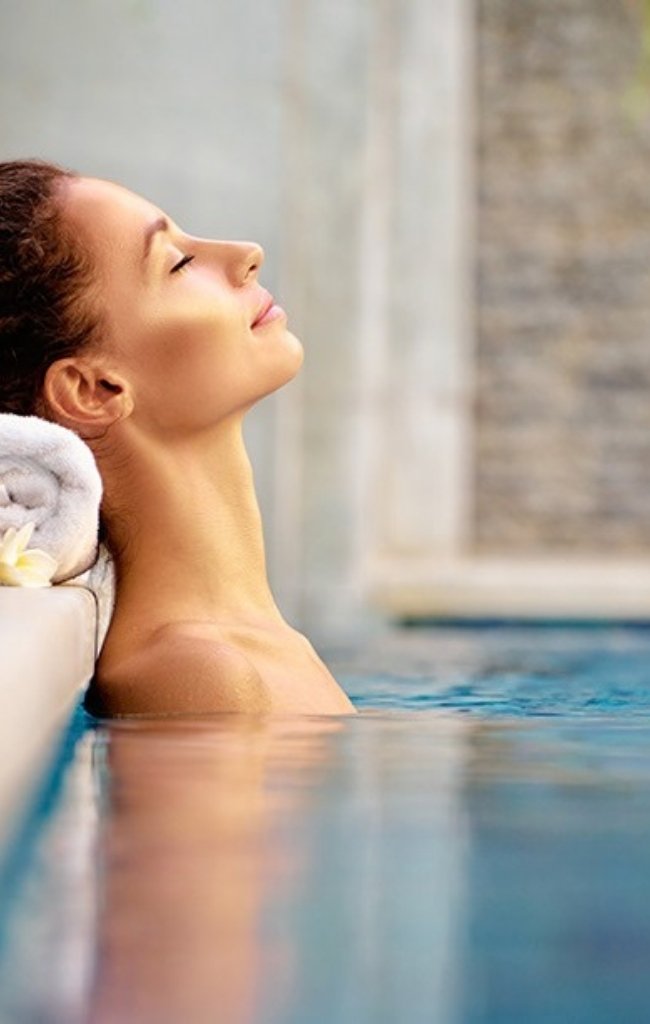 A woman relaxing at the edge of a spa pool