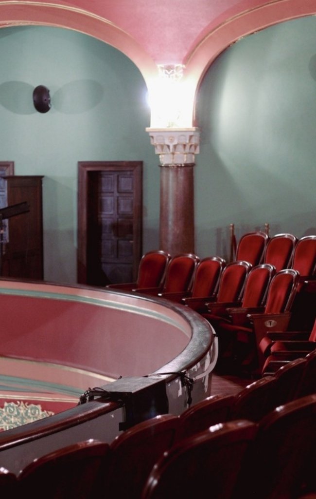 Red velvet seats in the balcony of a historic theater