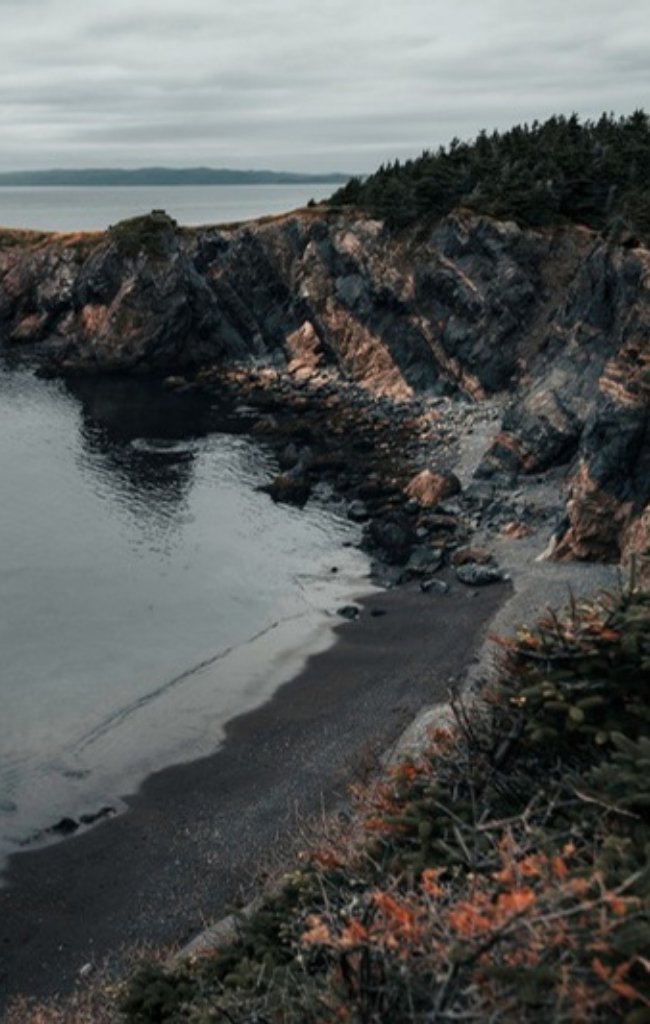 Coastal cliffs above a calm sea at Chance Cove