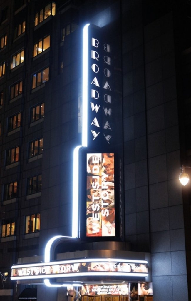 The lit vertical Broadway sign on a theater at night