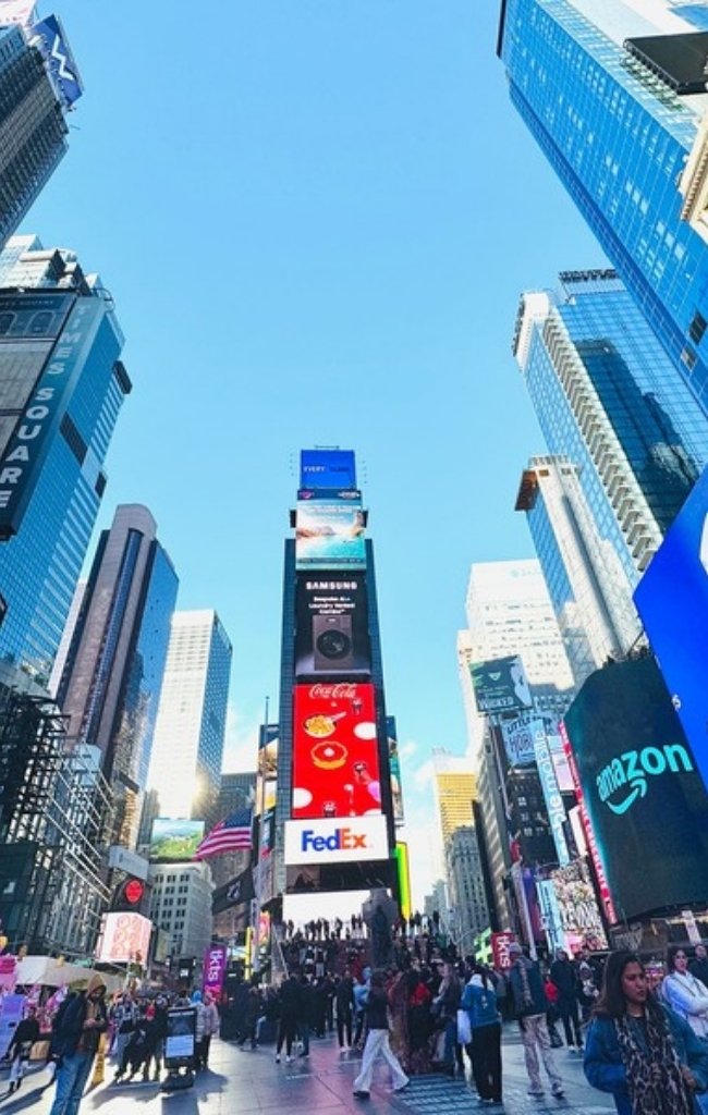 Crowds beneath the lit billboards of Times Square