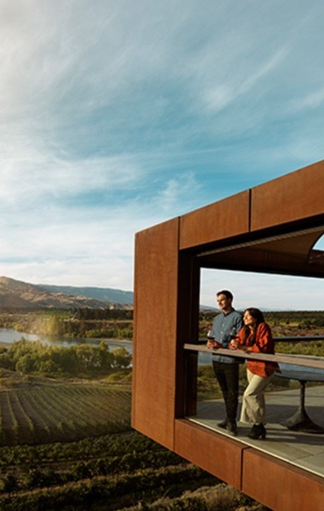 A couple at a vineyard lookout above the hills of Central Otago
