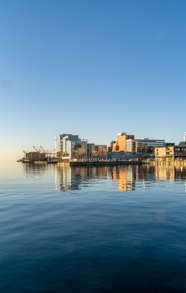 The Halifax waterfront reflected in the harbor at golden hour